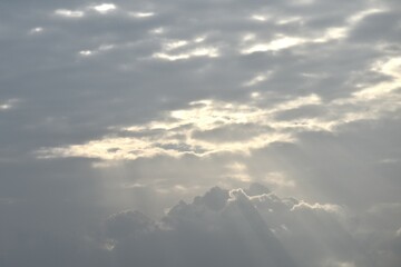 sun spreading light thourgh dark rain cloud floating on sky at sunset in evening