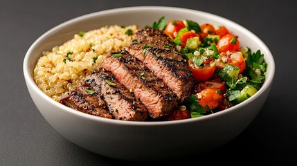Delicious grilled steak with quinoa and tomato salad in a bowl. Healthy food, diet, restaurant meal concept.