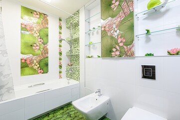 Bathroom with white tiles, green floral accents, a bathtub, a bidet, and glass shelves. Green,...