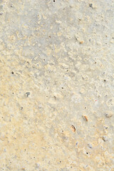 A rough, textured concrete surface in shades of yellow and grey