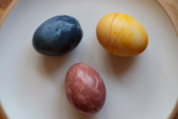 close up of dyed eggs in blue yellow and red