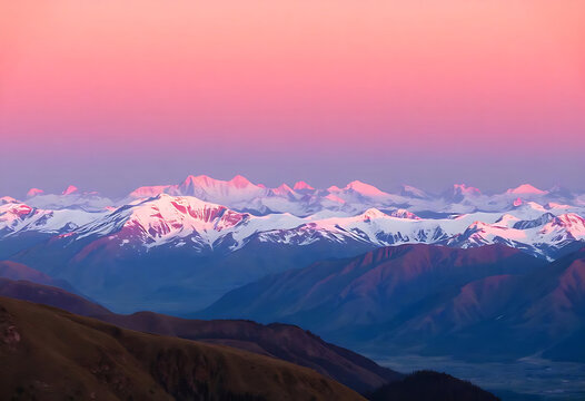Majestic snow capped mountains illuminated by the soft pink and purple tones of sunrise