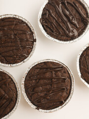 Brownies in a cup on wooden tray, on white background