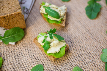 Sandwich with herring paste and greens on a burlap tablecloth