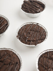 Brownies in a cup on wooden tray, on white background