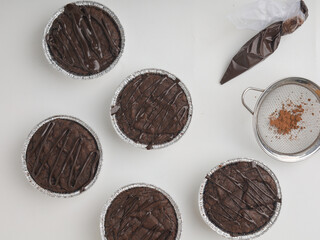 Brownies in a cup on wooden tray, on white background