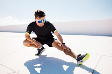 Dynamic Athlete Stretches on a Sunlit Rooftop at Midday, Preparing for an Exhilarating Workout With...