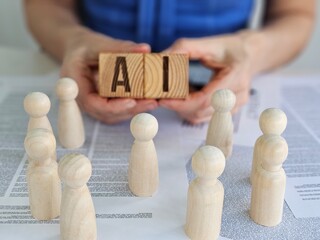 Wooden figures gather around a block with AI letters in a collaborative discussion about technology concept