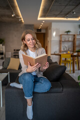 Woman enjoying a book in her modern apartment living room