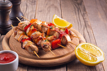 Delicious grilled chicken skewers with capsicum, lemon, salad and ketchup on a plate over the table. Chicken kebab. Healthy food concept.