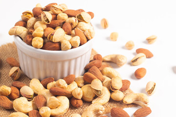 Large assortment of nuts in different bowls on stone table.