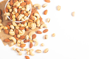 Large assortment of nuts in different bowls on stone table.
