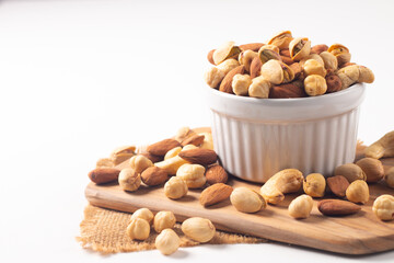 Large assortment of nuts in different bowls on stone table.