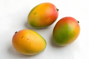 Top View of Three Ripe Mangoes on White Background