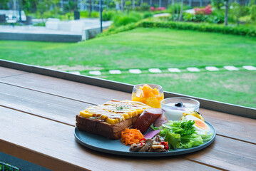 緑の美しい季節に、休暇で滞在したホテルの屋外のテラスでいただくラグジュアリーな朝食の風景
