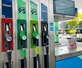 Repostar en gasolinera self service con mangueras de surtidor para llenar el depósito
