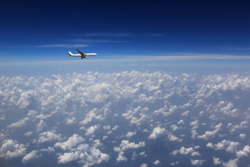 Airplane with beautiful cloud and blue sky from airplane window,Travel and transportation concept.