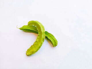 green pea pod. two winged beans isolated on a white background. a tropical legume with distinctive four-angled pods.