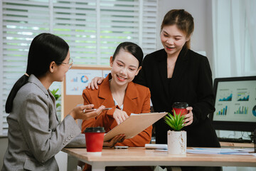 Asian business team collaborating in office, discussing strategy and project planning; professional...