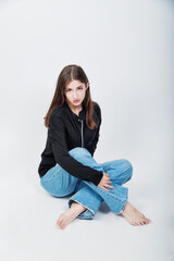 frau inm jeans sitz bei einem fotoshooting als model auf den boden, cool legere