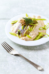 Herrings in mustard sauce. Bright wooden background.