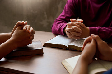 “Group Bible study with hands in prayer, reflecting spiritual connection, community, and...
