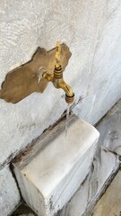 Muslim woman taking ablution for prayer.Ablution Faucets  In Sultan Ahmet Mosque