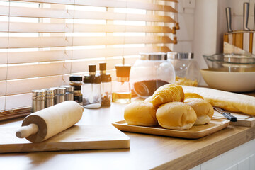 The croissant bread is placed on a wooden tray in the kitchen.