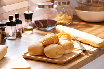 The croissant bread is placed on a wooden tray in the kitchen.