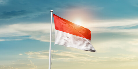Indonesia national flag waving in beautiful sky with mast. A proud moment flag waving with sunlight.