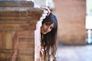 young, beautiful woman with cosmetic operations on her lips and cheekbones hides and peeks out from...