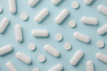 Flat Lay of White Pills on Light Blue Background, Clinical and Minimalist Medicine Concept
