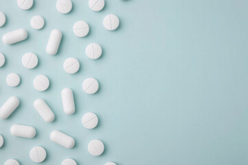 Flat Lay of White Pills on Light Blue Background, Clinical and Minimalist Medicine Concept