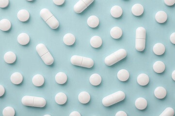Flat Lay of White Pills on Light Blue Background, Clinical and Minimalist Medicine Concept