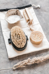 Flat lay of natural bathroom essentials: c, eco toothbrushes and bristle brushes, sea sponge, sea salt, washcloth. Zero-waste, plastic-free, beautifully styled in a calm, neutral setting