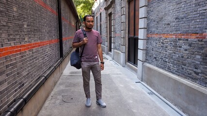 Man Walking Down a Brick Alleyway