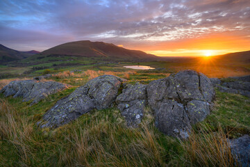 Dramatic golden sunrise overlooking Tewet Tarn and Blencathra in The Lake District, UK.
