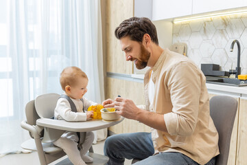 Single father having breakfast with his little baby boy