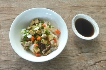 steamed large rice noodles topping chop pork and dice tofu with carrot dressing black soy sauce on plate 