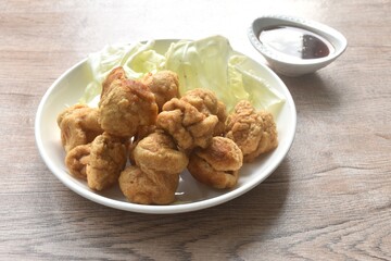 deep fried crispy fish ball dressing sweet chili tamarind sauce and slice cabbage on plate
