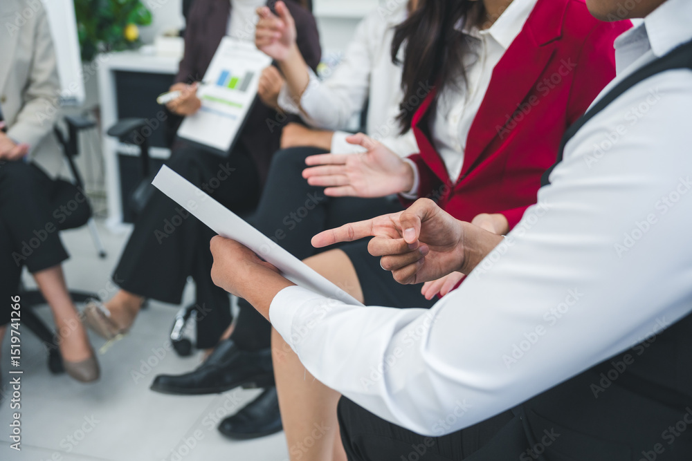 Aufkleber business team engaged in discussion while pointing at documents during a collaborative meeting in a 