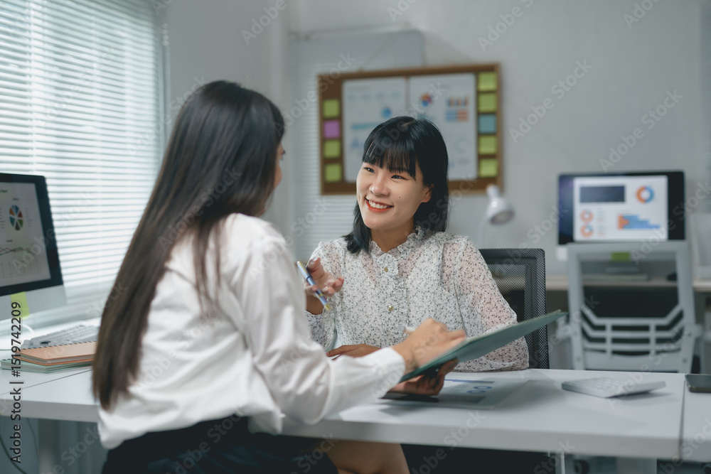 Aufkleber two asian businesswomen are discussing and working together using documents and computers in a lumin