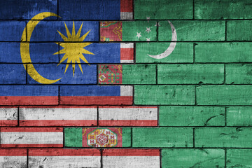 colourful painted big national flag of malaysia and flag of turkmenistan on a massive old brick wall background. concept