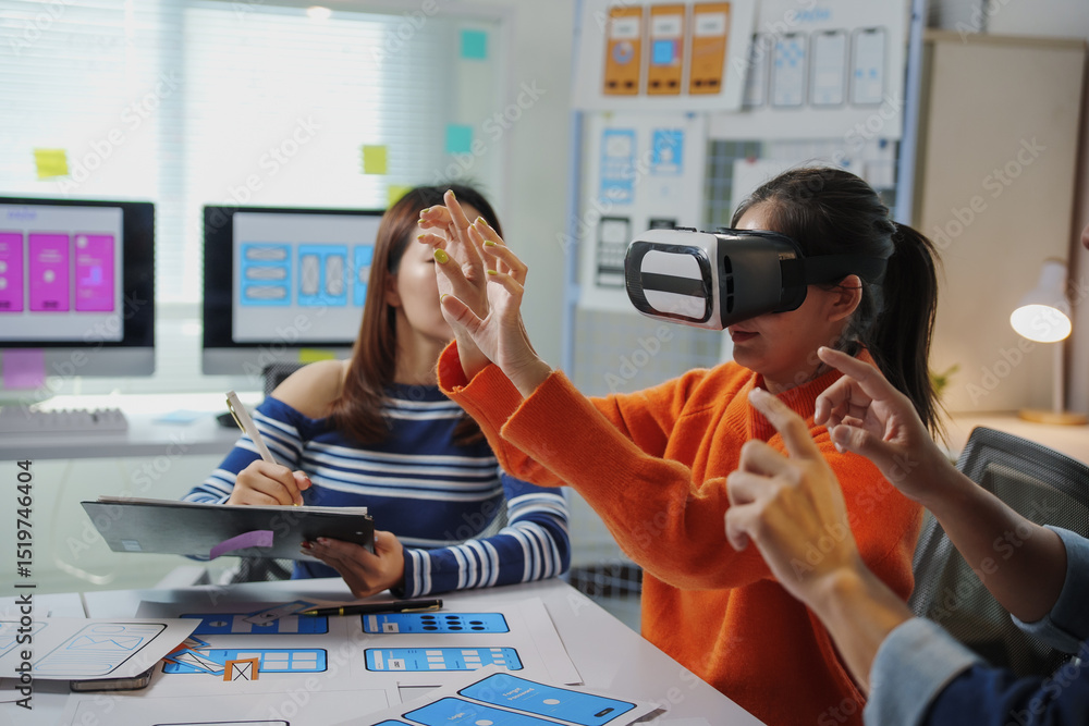Poster asian uiux web designers testing a virtual reality app in the office, wearing vr headsets and collab