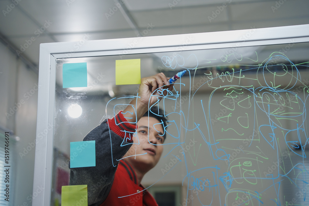 Poster young software developer drawing software design on glass board using colorful markers in modern off