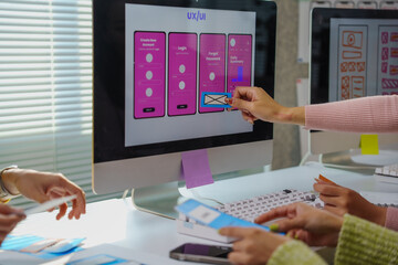 Designers working on user experience and user interface developing new mobile app using sticky...