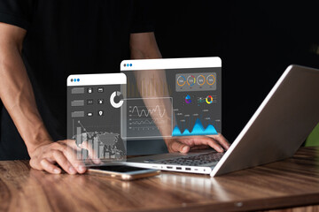 Man showing financial data graphic icons in front of laptop on virtual screen.