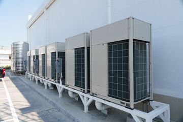 Air compressor or air condenser unit located on support outside building to heat released...
