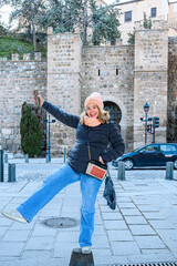Happy female tourist in a medieval town square, Toledo, Spain