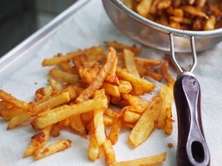 french fries on paper towel with sieve